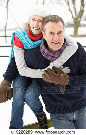 Stock Photo - Senior Couple Standing Outside In Snowy Landscape. Fotosearch