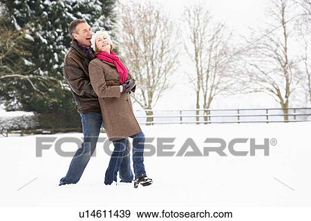 Stock Photo - Senior Couple Walking In Snowy Landscape. Fotosearch