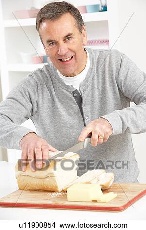 Senior Man Slicing Bread In Kitchen View Large Photo Image Picture - Senior Man Slicing Bread In Kitchen. Fotosearch