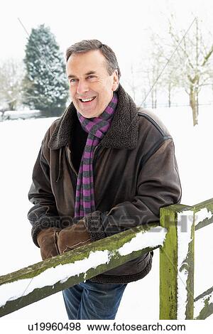 Senior Man Standing Outside In Snowy Landscape View Large Photo Image Stock Photo - Senior Man Standing Outside In Snowy Landscape. Fotosearch