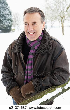 Stock Photo - Senior Man Standing Outside In Snowy Landscape. Fotosearch