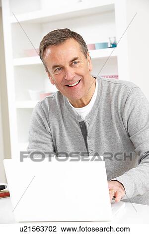 Stock Image - Senior Man Using Laptop At Home. Fotosearch