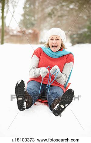 Senior Woman Sledging Through Snowy Woodland View Large Photo Image Stock Image - Senior Woman Sledging Through Snowy Woodland. Fotosearch