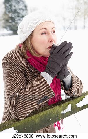 Senior Woman Standing Outside In Snowy Landscape Warming Hands View Large Photo Image Stock Photo - Senior Woman Standing Outside In Snowy Landscape Warming Hands. Fotosearch