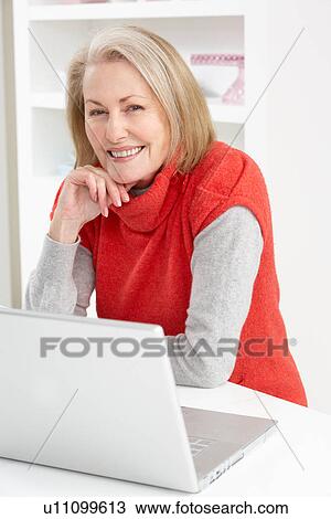 Stock Image - Senior Woman Using Laptop At Home. Fotosearch