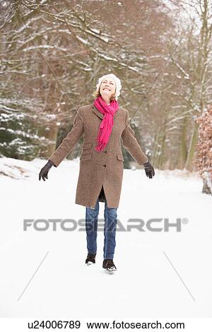 Senior Woman Walking Through Snowy Woodland View Large Photo Image Stock Photo - Senior Woman Walking Through Snowy Woodland. Fotosearch