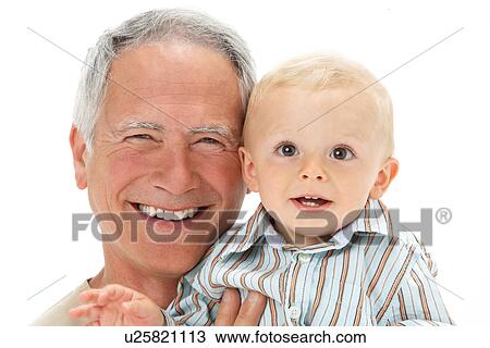 Stock Image - Studio Portrait Of Grandfather Holding Grandson. Fotosearch
