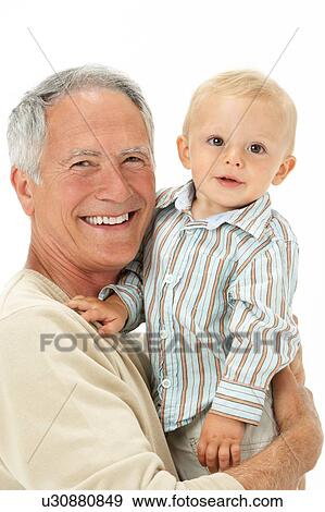 Stock Photo - Studio Portrait Of Grandfather Holding Grandson. Fotosearch