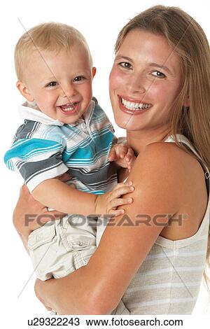 Stock Image - Studio Portrait Of Mother Holding Son. Fotosearch