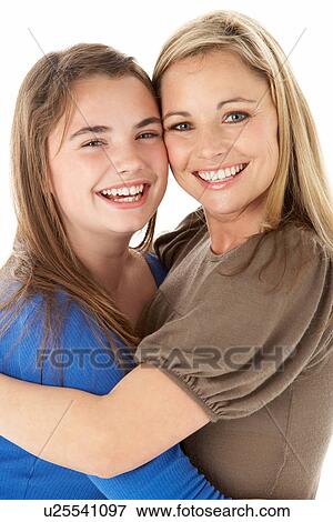 Stock Photo - Studio Portrait Of Mother Hugging Daughter. Fotosearch