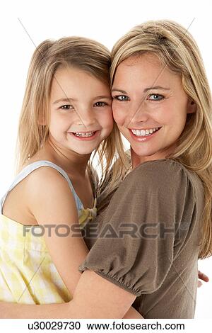 Stock Image - Studio Portrait Of Mother Hugging Young Daughter. Fotosearch
