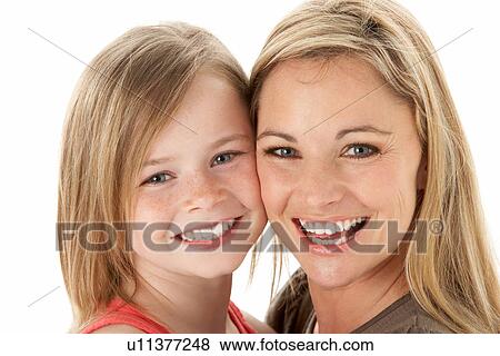 Stock Photo - Studio Portrait Of Mother Hugging Young Daughter. Fotosearch