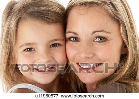 Stock Photo - Studio Portrait Of Mother Hugging Young Daughter. Fotosearch