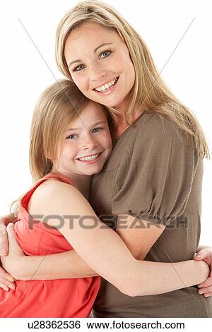 Stock Photograph - Studio Portrait Of Mother Hugging Young Daughter. Fotosearch