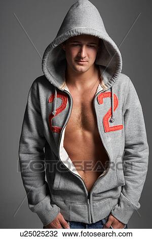Stock Image - Studio Portrait Of Sexy Young Man Wearing Hooded Sweat Top. Fotosearch