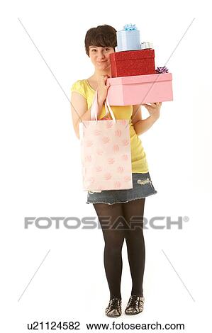Stock Image - Studio Portrait Of Teenage Girl Carrying Packages And Shopping Bags. Fotosearch