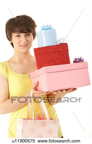 Stock Photography - Studio Portrait Of Teenage Girl Carrying Packages And Shopping Bags. Fotosearch