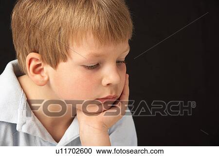 Stock Image - Studio Portrait Of Thoughtful Young Boy. Fotosearch