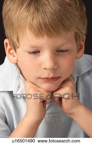 Stock Image - Studio Portrait Of Thoughtful Young Boy. Fotosearch