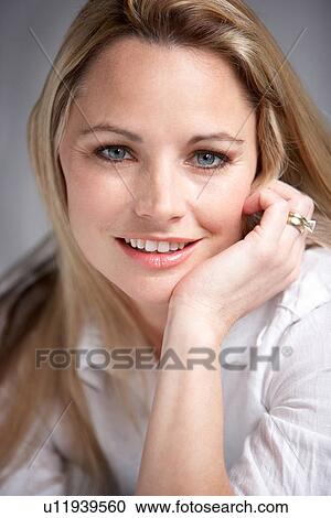 Stock Image - Studio Portrait Of Woman Wearing White Shirt. Fotosearch