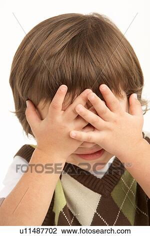 Stock Image - Studio Portrait Of Young Boy Covering Eyes. Fotosearch