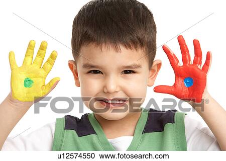Stock Image - Studio Portrait Of Young Boy With Painted Hands. Fotosearch