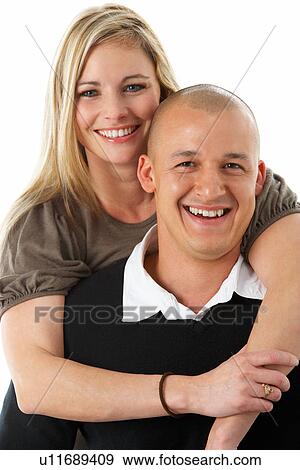 Stock Photo - Studio Portrait Of Young Couple Hugging. Fotosearch