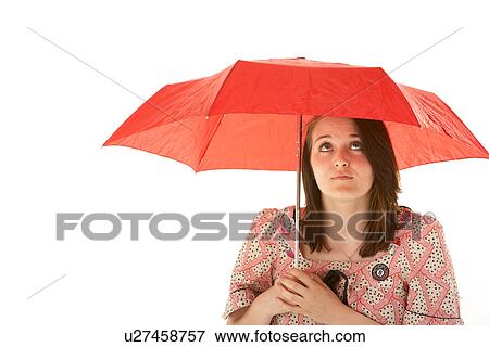 Stock Photo - Studio Shot Of Teenage Girl Standing Under Red Umbrella. Fotosearch