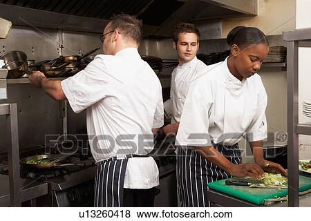 Stock Photo - Team Of Chefs Preparing Food In Restaurant Kitchen. Fotosearch