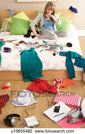 Stock Image - Teenage Girl In Untidy Bedroom. Fotosearch