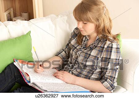 Stock Photo - Teenage Girl Studying At Home Sitting On Sofa. Fotosearch