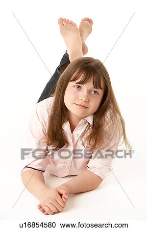 Stock Image - Thoughtful Young Girl Lying On Stomach In Studio. Fotosearch