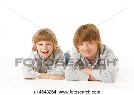 Two Young Boys Lying On Stomach In Studio View Large Photo Image Picture - Two Young Boys Lying On Stomach In Studio. Fotosearch