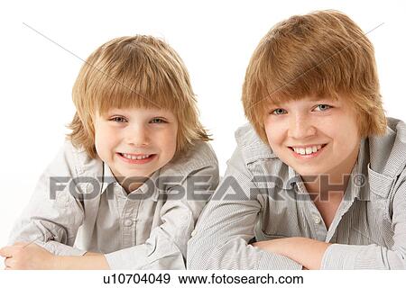 Stock Photo - Two Young Boys Lying On Stomach In Studio. Fotosearch