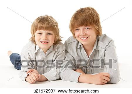 Two Young Boys Lying On Stomach In Studio View Large Photo Image Stock Photo - Two Young Boys Lying On Stomach In Studio. Fotosearch