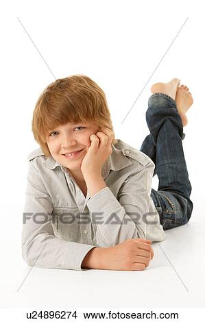 Picture - Young Boy Lying On Stomach In Studio. Fotosearch