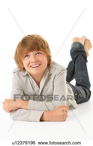 Stock Photograph - Young Boy Lying On Stomach In Studio. Fotosearch