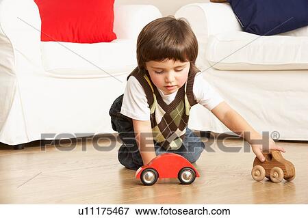 Stock Photo - Young Boy Playing With Toy Cars At Home. Fotosearch