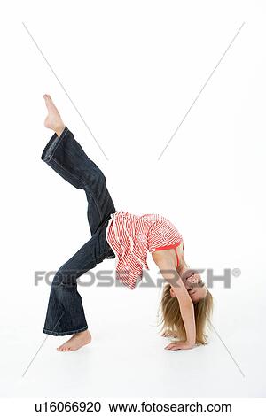 Stock Image - Young Girl Doing Backflip In Studio. Fotosearch