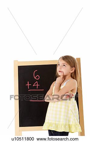 Stock Image - Young Girl Looking Thoughtful Next To Blackboard. Fotosearch