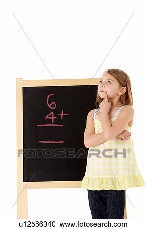 Stock Image - Young Girl Looking Thoughtful Next To Blackboard. Fotosearch