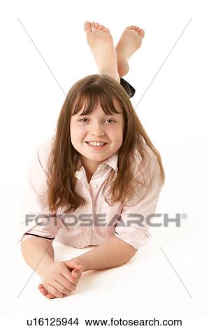 Picture - Young Girl Lying On Stomach In Studio. Fotosearch