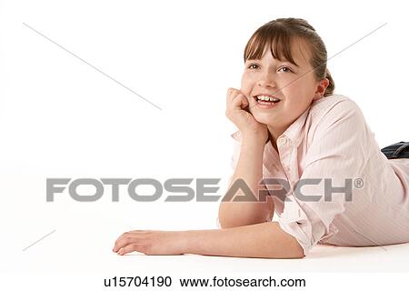 Stock Image - Young Girl Lying On Stomach In Studio. Fotosearch
