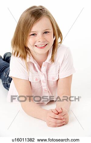 Stock Image - Young Girl Lying On Stomach In Studio. Fotosearch