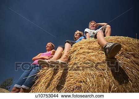 Picture - 3 farm kids on bales; Redvers, Saskatchewan, Canada. Fotosearch