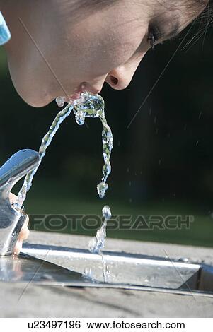 Asian woman drinks from water fountain in Assiniboine Park, Winnipeg, Canada View Large Photo Image Stock Photograph - Asian woman drinks from water fountain in Assiniboine Park, Winnipeg, Canada. Fotosearch