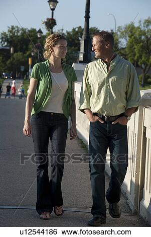 Couple in their 40's strolling over pedstrian bridge in Assiniboine Park, Winnipeg, Canada View Large Photo Image Stock Photograph - Couple in their 40's strolling over pedstrian bridge in Assiniboine Park, Winnipeg, Canada. Fotosearch