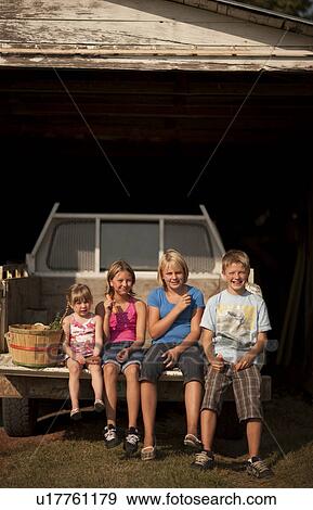 Cousins (five, ten, twelve and twelve) eating carrots in the back of pick-up truck; Redvers, Saskatchewan, Canada View Large Photo Image Stock Photo - Cousins (five, ten, twelve and twelve) eating carrots in the back of pick-up truck; Redvers, Saskatchewan, Canada. Fotosearch