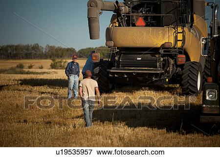Stock Photo - Farmer and grandson, grain truck and combine in field, Redvers, Saskatchewan, Canada. Fotosearch