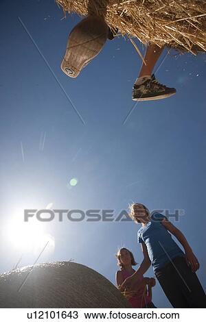 Feet hang over edge of bales, two girls look on; Redvers, Saskatchewan, Canada View Large Photo Image Stock Image - Feet hang over edge of bales, two girls look on; Redvers, Saskatchewan, Canada. Fotosearch
